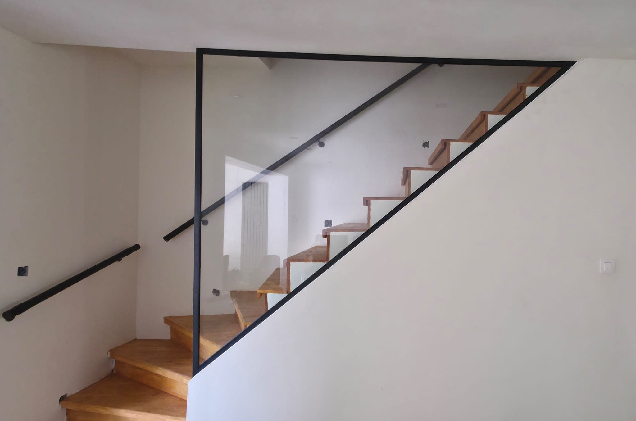 Grande paroi en verre à profils noirs dans un intérieur moderne