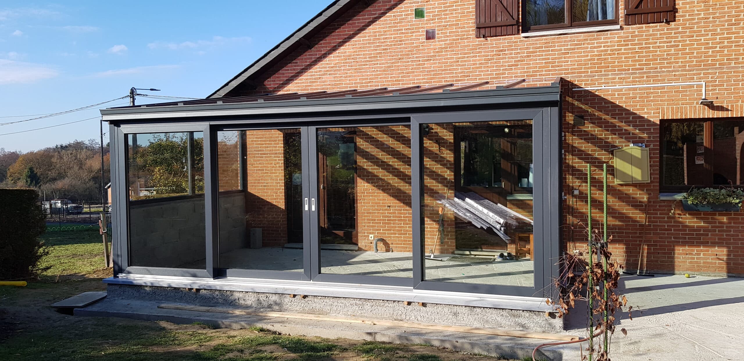 Véranda en verre et aluminium attenante à une maison