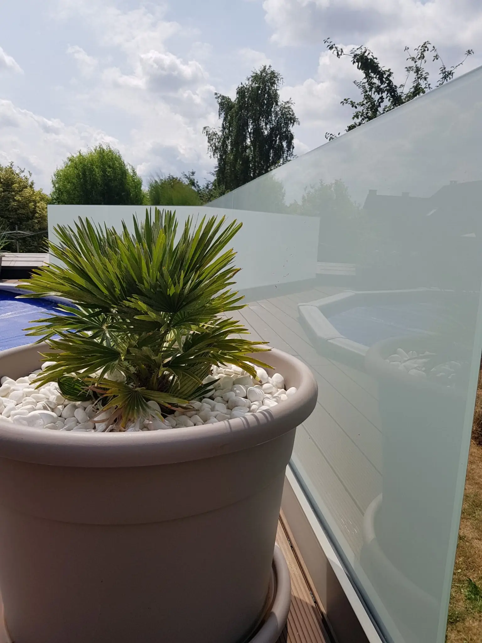 Coupe-vent transparent en verre installé sur une terrasse Coupe-vent transparent en verre installé sur une terrasse